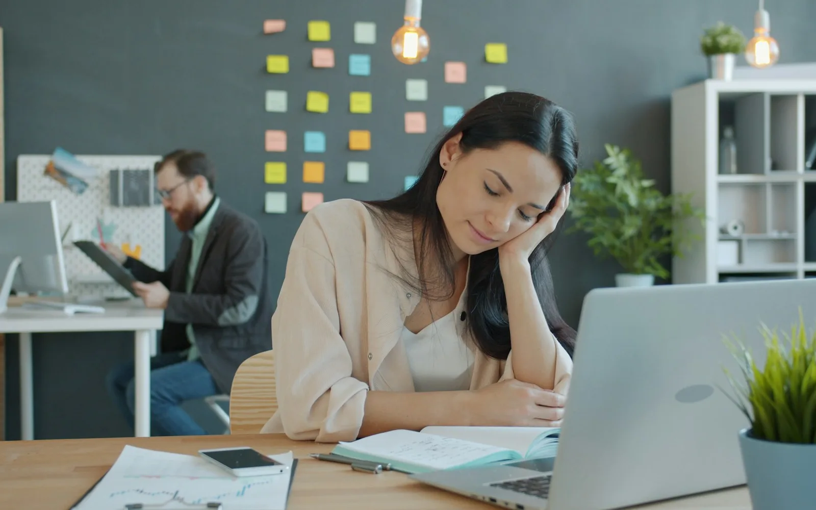 Professionnelle épuisée, la tête appuyée sur la main devant son ordinateur portable au bureau
