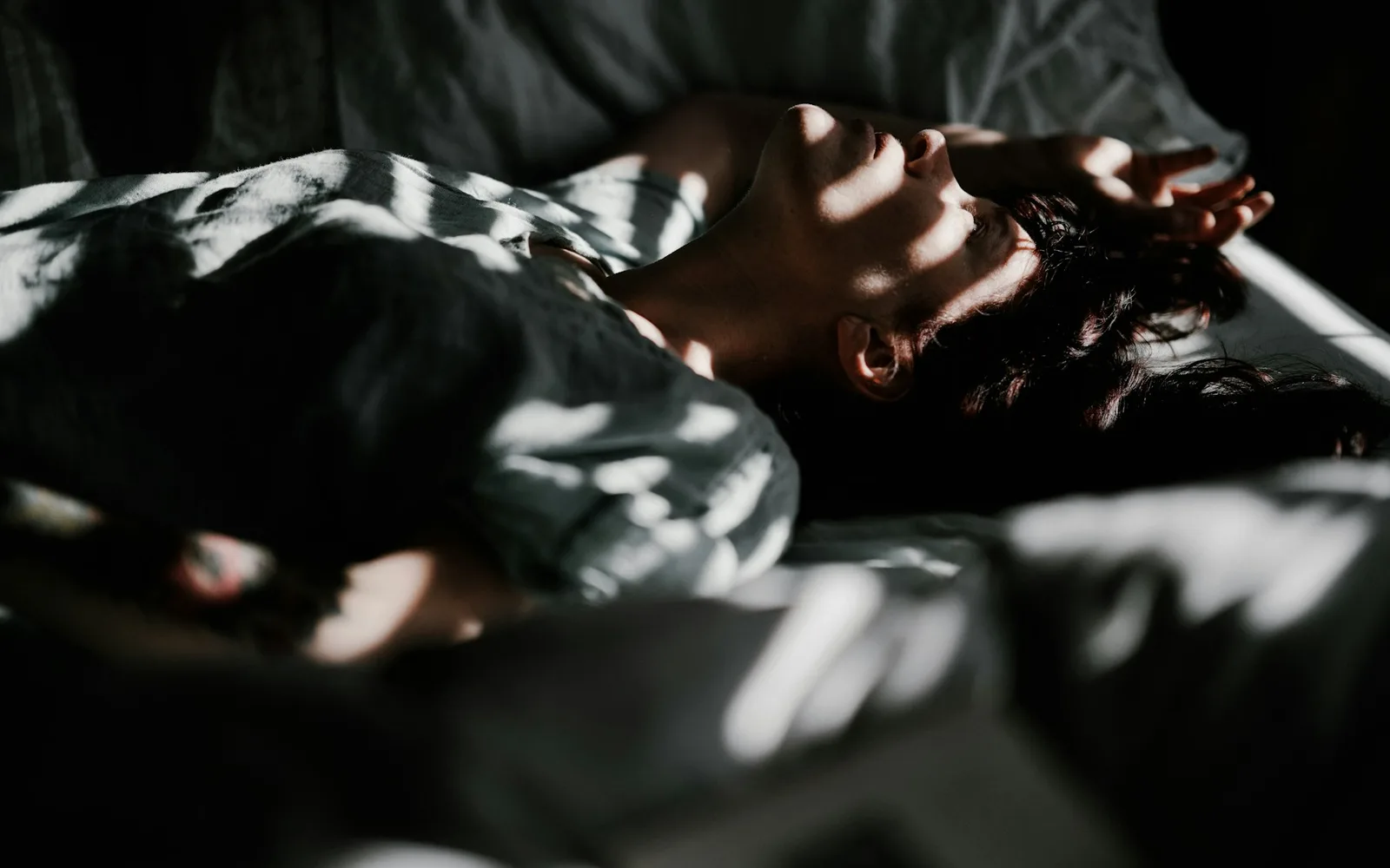 Personne endormie paisiblement, la tête sur l'oreiller, dans la lumière du matin